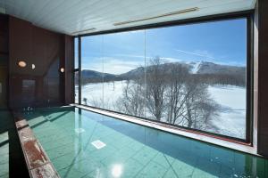 山之内町奥志贺凤凰大酒店的享有白雪 ⁇ 山景的游泳池