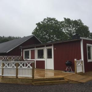 科尔莫登Bränntorps Gård的红色的建筑,设有门廊和甲板