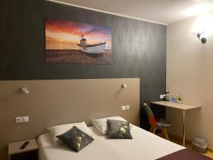 古尔奈昂布赖诺曼底酒店的卧室配有一张床,墙上有一条船