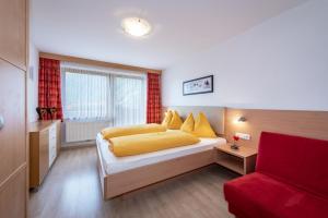 瓦勒斯Residence Tauber的一间卧室配有一张床和一张红色的沙发