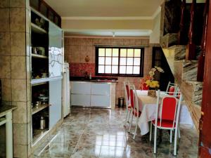 圣若昂-德雷Casa da Tuca的厨房配有桌子和红色椅子