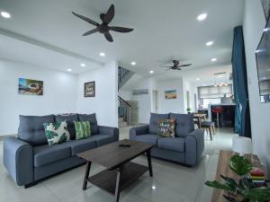 Bandar PenawarDesaru Comfy Home with Netflix Near Beach, Waterpark & BBQ的客厅配有2张蓝色的沙发和1张桌子
