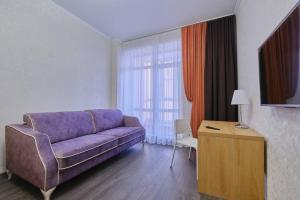 托木斯克Апартаменты Петровские однокомнатные Трифонова 22的客厅配有紫色沙发和桌子