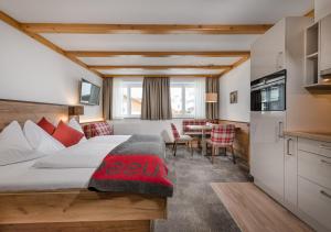 上陶恩Apartments & Garni Alpenrose的酒店客房配有一张床铺和一张桌子。
