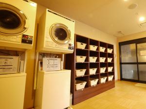 半田半田龟崎茹特酒店的洗衣房配有洗衣机和烘干机(墙上)