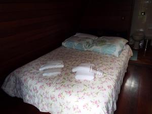 蒙特韦尔迪Pousada Perola da Mantiqueira的一张带两条毛巾和两个枕头的床