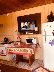 乌鲁比西Casa da Vó Adelina的厨房配有带微波炉的桌子和电视。