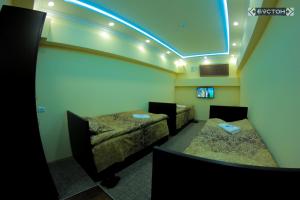 ChkalovskHostel Buston的一间设有两张床和蓝色灯光的房间