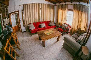 伊瓜苏港蒂拉科罗拉达酒店的客厅配有红色的沙发和桌子