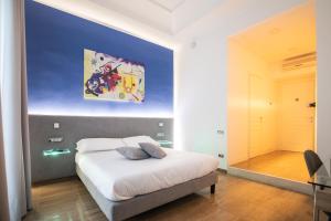 那不勒斯Sanfelice 33 Luxury Suites的卧室配有一张床,墙上挂有绘画作品