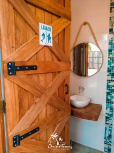 普拉亚弗朗西丝Pousada Charme Francês的浴室设有木门、水槽和镜子