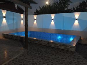 巴拉德尔楚Casa VIRAMAR的夜间游泳池,墙上有灯