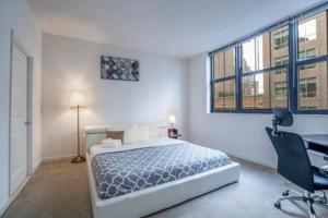 巴尔的摩巴尔的摩港畔希文公寓的卧室配有一张床、一张书桌和窗户。