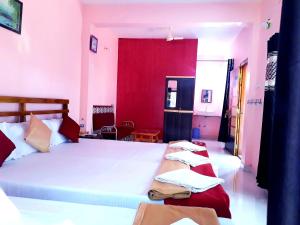 马尔万Samant Beach Resort的一间卧室设有两张床和红色的墙壁