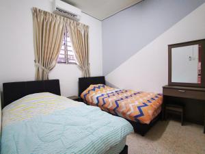 巴特沃思Bagan Terrace House near to Sunway Carnival Mall, Seberang Jaya的一间卧室配有两张床、一个梳妆台和镜子