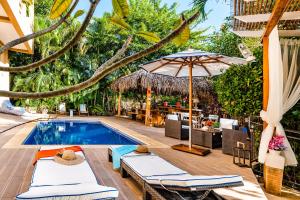 塔马林多鹦鹉螺别墅酒店的毗邻度假酒店的带椅子和遮阳伞的游泳池