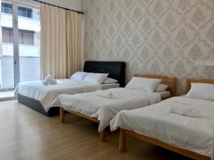 峇六拜Island Hostel的带三张床和窗户的客房