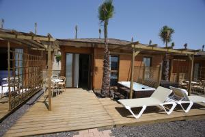贝尼多姆Magic Natura Resort的一个带椅子和桌子的甲板和棕榈树