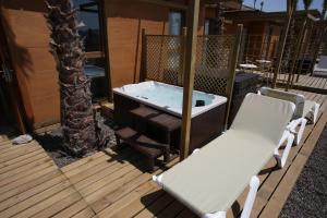贝尼多姆Magic Natura Resort的甲板上配有热水浴缸和两把椅子