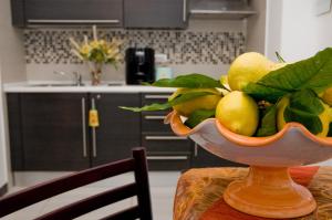 马奥莱B&B Galatea的厨房里的桌子上放着一碗水果