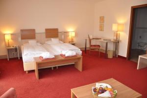 巴特赫尔斯费尔德艾姆科帕克酒店的酒店客房配有一张床铺和一张桌子。