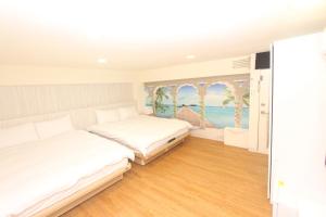 基隆Sea Keelung的一间卧室设有两张床,墙上挂着一幅画