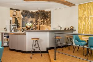 Hotel Am Dom的厨房配有蓝色的酒吧凳子和墙上的绘画作品