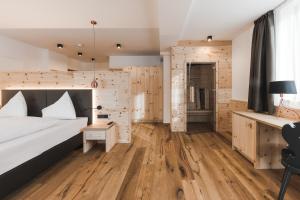 雷西亚Hotel Zum Mohren的一间卧室设有一张床和木墙