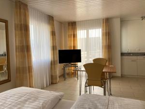 Sankt GallenkappelLandgasthof Krone Bed & Breakfast的酒店客房设有床、桌子和电视。
