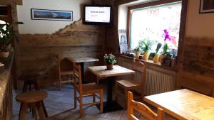 圣尼古拉斯Appartamenti Le Bistrot的餐厅设有木桌、椅子和窗户