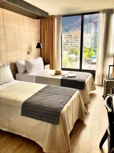 圣地亚哥RQ Santa Magdalena的酒店客房设有两张床和大窗户。