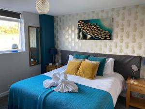 Saltford临江旅馆的卧室配有蓝色和白色的床,床上有弓