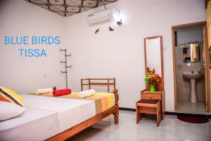蒂瑟默哈拉默Blue Birds Tissa & Yala safari的卧室的墙上挂着蓝色鸟 ⁇ 标志