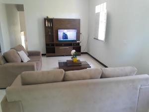 盖比姆Casa de Temporada Guaibim的带沙发和电视的客厅