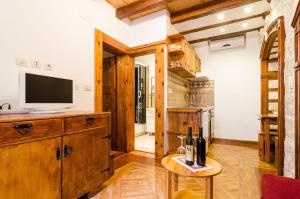杜布罗夫尼克城市之灵公寓的客厅配有电视和带葡萄酒瓶的桌子。