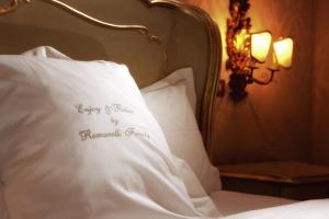 威尼斯弗洛拉酒店的一张带白色枕头的床,上面有幸福的新娘标志