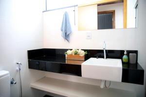 迪亚曼蒂纳Apartamento Premium的浴室设有白色水槽和镜子