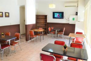 维拉卡洛斯帕兹Hotel Brisas的一间带桌椅的餐厅以及墙上的电视