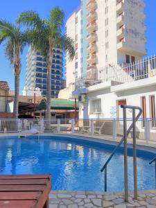 维拉卡洛斯帕兹Hotel Brisas的一座棕榈树和建筑的大型游泳池