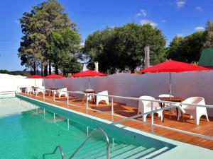 拉库布蕾Portal de La Cumbre的甲板上配有桌子和遮阳伞的游泳池