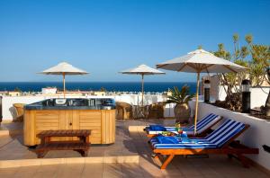 英格兰海滩海滨沙滩酒店的一个带两把椅子和热水浴缸的庭院