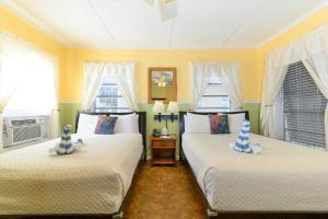 基韦斯特棕榈酒店的配有两张床铺的黄色墙壁和窗户