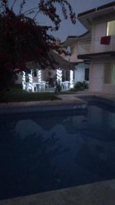 特科卢特拉Villa kosniin的夜间在房子前面的游泳池