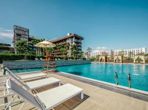 三亚 三亚1Hotel海棠湾阳光壹酒店（可持续发展理念）的一个带躺椅和遮阳伞的游泳池