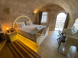 乌奇希萨尔Mimi Cappadocia Luxury Cave Hotel的石屋设有一间带大床的卧室