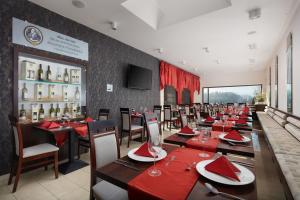 耶塞尼克斯拉尼德芙酒店的用餐室配有桌椅和红色餐巾