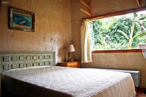 马德普拉塔Bosque Peralta Ramos Cabañas Nalu 1的一间卧室设有一张大床和一个窗户。