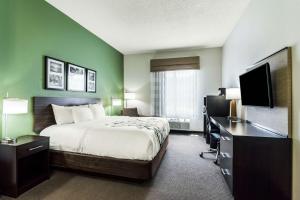 史密斯菲尔德Sleep Inn & Suites Smithfield near I-95的酒店客房配有一张床、一张书桌和一台电视。