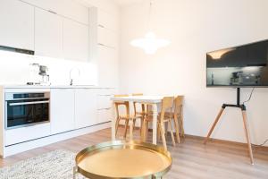 奥卢Apartment City的厨房配有白色橱柜和桌椅
