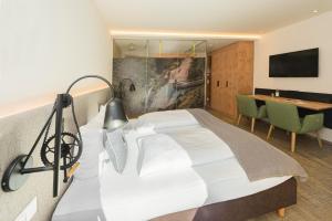 基茨比厄尔附近奥拉赫Lifesport Hotel Hechenmoos的一间卧室配有一张床、一张桌子和一张书桌